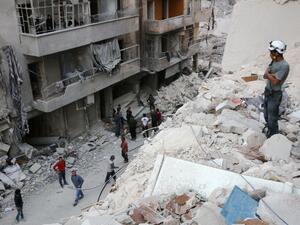 A Syrian civil defence volunteer, known as the White Helmets, stands on the rubble of destroyed buildings during a rescue operation following a government forces air strike on the rebel-held neighbourhood of Bustan al-Basha in Aleppo. (AFP/Thaer Mohammed)