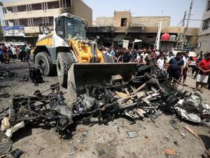 A bulldozer clears the wreckage following a car bomb attack in Sadr City, a Shiite area north of the capital Baghdad, on May 11, 2016. (AFP/Agmad Al Rubaye)