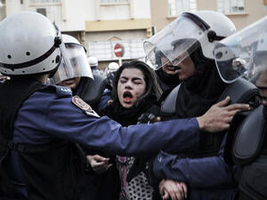 A protestor cries after being pepper sprayed as she is arrested by riot policemen on January 18, 2013. (AFP Photo / Mohammed Al-Shaikh)