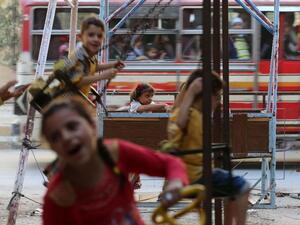 Syrian children play on swings in Arbin, on the outskirts of the capital Damascus, as they celebrate the Muslim Eid al-Adha holiday on September 13, 2016. (AFP/Amer Almohibany)
