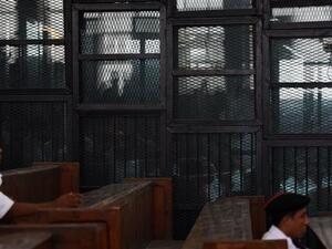 Egyptian Muslim Brotherhood defendants, including leader Mohamed Badie, stand behind bars during a trial in Cairo on August 22, 2015. (AFP/File)