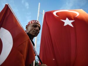A Pro-Erdogan supporter holds a Turkish national flag during a rally at Taksim Square in Istanbul on July 18, 2016 (AFP/Aris Messinis)
