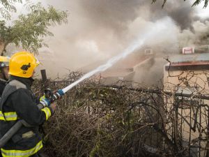 Israeli firefighters help extinguish a fire in the northern Israeli port city of Haifa on November 24, 2016. (AFP/Jack Guez)