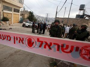 Israeli security forces gather at the scene where a Palestinian stabbed an Israeli soldier before he was shot dead, in the flashpoint West Bank city of Hebron. (AFP/Hazem Bader)