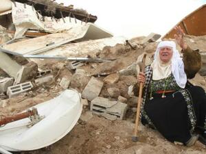 A Palestinian woman sits next to the remains of her home after it was demolished by Israeli bulldozers in the West Bank town of Hebron. (AFP/File) 