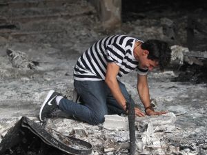 An Iraqi man reacts as he enters a building that was destroyed in a suicide-bombing attack in Baghdad's Karrada neighbourhood (AFP/Ahmad al-Rubaye)