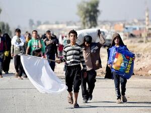 An Iraqi family walks with a white flag as they leave Gogjali, which lies on the eastern edge of Mosul. (AFP/File) 