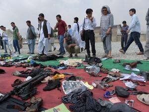 Relatives and friends inspect shoes and other belongings of those who were killed in the twin suicide attack, gathered on the ground at a mosque in Kabul on July 24, 2016. (AFP/Shah Marai) 