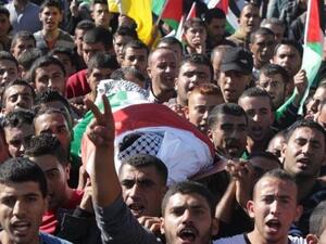 Palestinian mourners carry the body of Mahmud Shalaldeh, 18, who was shot by Israeli troops during clashes the previous day in Hebron, during his funeral on November 13, 2015. (AFP/Hazem Bader)