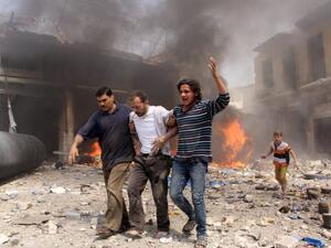 Syrian men help an injured person following a reported barrel bomb attack by Syrian government forces that hit an open market in the northern city of Aleppo, on June 3, 2015, killing and injuring people. (AFP/Karam al-Masri)