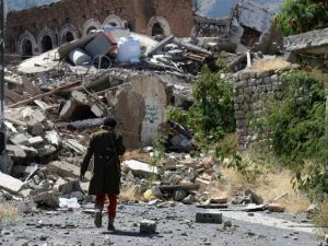 A Yemeni man inspects the damage on a street following clashes on November 22, 2016 in Taez. (AFP/Ahmad Al Bashar)