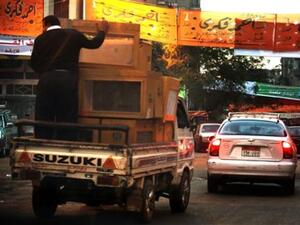 رجل أمن مصري يمسك صندوق اقتراع متجها إلى مركز انتخابي حيث تجري انتخابات مجلس الشعب اليوم الأحد