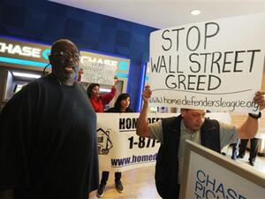 أمريكيون مهددون بالطرد من بيوتهم يتظاهرون أمام مكتب تابع لأحد البنوك.
