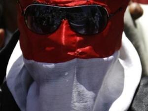 متظاهر يمني وقد لف وجهه بالعلم الوطني. متظاهر يمني وقد لف وجهه بالعلم الوطني.