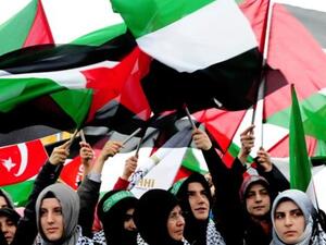 نساء تركيات يرفعن أعلاما فلسطينية.