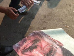 متظاهر يحاول حرق صورة الرئيس مرسي متظاهر يحاول حرق صورة الرئيس مرسي