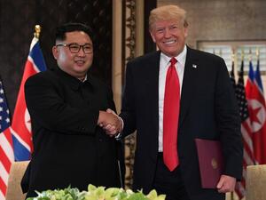 North Korea's leader Kim Jong Un (L) shakes hands with US President Donald Trump (R) after taking part in a signing ceremony at the end of their historic US-North Korea summit, at the Capella Hotel on Sentosa island in Singapore on June 12, 2018. (Anthony WALLACE / POOL / AFP)