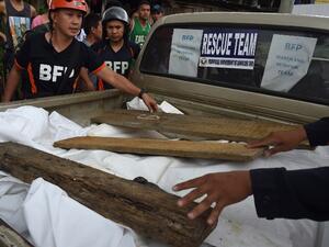 Rescue personnel remove weights securing a tarp over a vehicle transporting the corpses of dead civilians retrieved near the frontline in the outskirts of Marawi on the southern island of Mindanao on June 28, 2017. (Ted Aljibe/AFP)