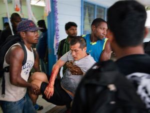 File photo of an injured Afghan refugee (C) from an Australian detention facility in Manus Island being carried by two men after he was allegedly attacked by a group of Papua New Guinean men while out on a day release. (AFP/File) 