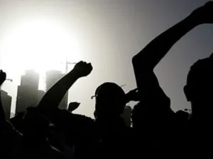 متظاهرون يرفعون قبضاتهم في الهواء في ساحة اللؤلؤة في وسط المنامة