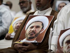A Bahraini man holds a placard bearing the portrait of Sheikh Ali Salman, head of the Shia opposition movement Al-Wefaq, during a protest against his arrest outside Manama. (AFP/Mohammed al-Shaikh)