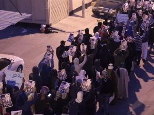 Bahrainis protest death sentences issued against three of their compatriots, while holding up protest placards and pictures of jailed cleric Sheikh Issa Qassim, in the northwestern village of Diraz, January 15, 2014. (File photo)