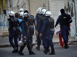 Bahraini riot police forces detain a man as they collect the national flags and banners of protesters during an anti-government protest in the village of Malikiya, South of Manama on June 23, 2012. (AFP/Mohammed al-Shaikh)