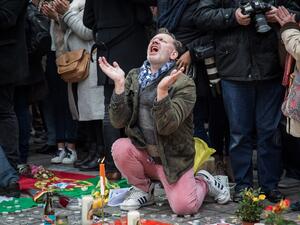 A man reacts as people gather to observe a minute of silence in memory of the victims of the Brussels airport and metro bombings, on the Place de la Bourse in central Brussels, on March 23, 2016, a day after the triple blasts killed some 30 people and left around 250 injured. (AFP/Aurore Belot)