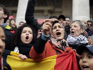 People sing as they gather around a makeshift memorial at the Place de la Bourse in Brussels on March 23, 2016, a day after blasts hit the Belgian capital. (AFP/Kenzo Tribouillard)