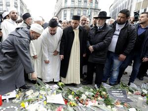 People leave flowers at a make-shirt memorial following a commemorative march at La Bourse in Brussels on March 22, 2017 as Belgium marks the first anniversary of the twin Brussels attacks by Islamic extremists. (AFP/Thierry Roge)