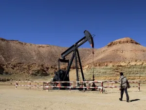 A Libyan security member walks past an oil drill on the Al-Ghani oil field near the city of Waddan on March 23, 2013. (AFP)