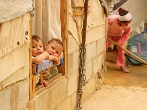 Syrian refugee children look on from a window during a sandstorm at a refugee camp on September 8, 2015 near the Bekaa Valley village of Taalabaya Lebanon. (AFP/File)