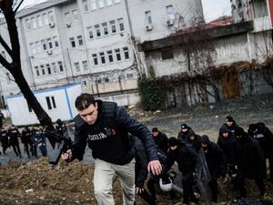 Turkish anti-riot policemen take cover during clashes with two female assailants, on March 3, 2016, in the Bayrampasa neighborhood in Istanbul, after the two women hurled grenades and opened fire at an Istanbul police station. (AFP/Ozan Kose)