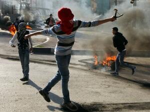 Palestinian protesters throw stones towards Israeli security forces during clashes in the West Bank city of Hebron on November 20, 2015. (AFP/Hazem Bader)