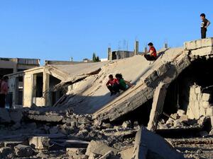 Children play on the rubble of a destroyed building in the rebel-held city of Daraa, Syria. (AFP/Mohamad Abazeed)