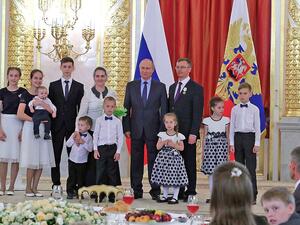 President Vladimir Putin poses for photos with Russia’s biggest families (Twitter)