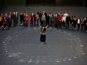 Tania Bruguera, centre, and guests stand after lying on her artwork, a heat-sensitive floor, in the Turbine Hall at the Tate Modern (Twitter)