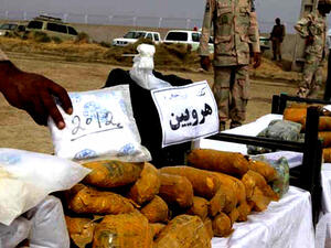 An Iranian officer displays packages of seized Afghan-made drugs (AFP)