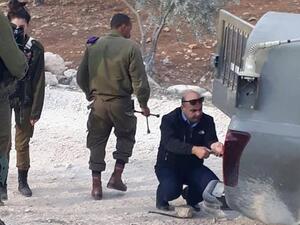 العقيد احمد ابو الرب اثناء اصلاحه لاطار مركبة دورية الجيش الاسرائيلي