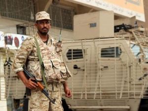 أحد جنود الجيش اليمني يقف بجوار مدرعة في عدن

