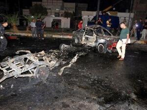 قوة أمن عراقية تعاين موقع تفجير سيارة ملغومة في مدينة كركوك في شمال العراق
