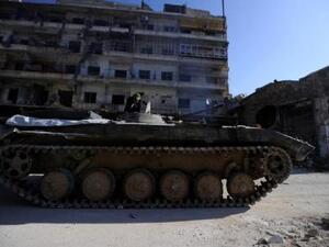 أحد أفراد قوات الجيش السوري على عربة مصفحة في منطقة في حلب تسيطر عليها قوات الجيش يوم الجمعة
