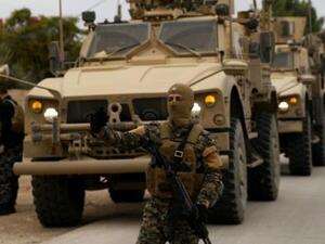 عناصر من قوات سوريا الديموقراطية وجنود اميركيون يقومون بدورية في بلدة الدرباسية في شمال شرق سوريا قرب الحدود التركية
