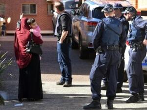 الشرطة توضح للسكان الطرق التي عليهم أن يسلكوها حول مبان في ضاحية لاكيمبا بتاريخ 1 آب/اغسطس، 2017، بعد عمليات دهم جرت في أنحاء مدينة سيدني

