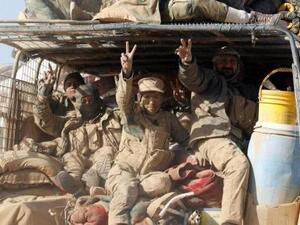 أفراد من مقاتلي منظمة بدر الشيعية يستقلون مركبة عسكرية خلال قتال مع تنظيم الدولة الإسلامية في غرب الموصل
