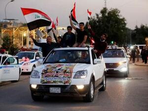 عراقيون يرفعون علم بلادهم احتفالا بالذكرى الاولى للانتصار على تنظيم الدولة الاسلامية في بغداد
