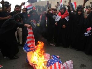 حرق العلم الاميركي خلال تظاهرة في بغداد احتجاجا على قصف سوريا
