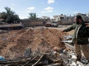 أحد عناصر القوات الليبية يتفقد موقعا قصفته طائرة أمريكية في احدى ضواحي بنغازي

