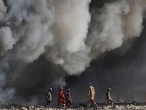عمال نفط عراقيون قرب حقول نفط أشعلها تنظيم الدولة الإسلامية في القيارة إلى الجنوب من الموصل
