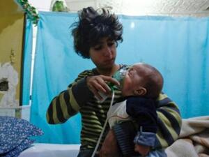 سوري يضع قناع اوكسيجين لطفل في مستشفى في دوما في الغوطة الشرقية بشرق دمشق 
